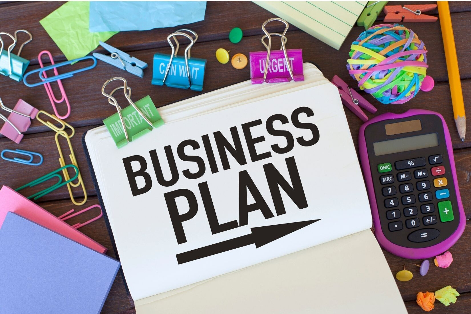 Graphic featuring the words "business plan" with office supplies surrounding graphic.