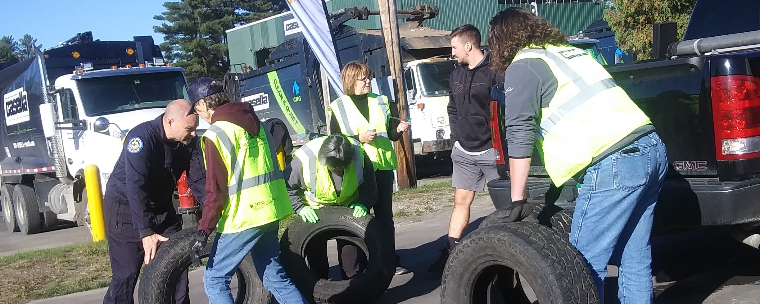 a group of volunteers moving car tires