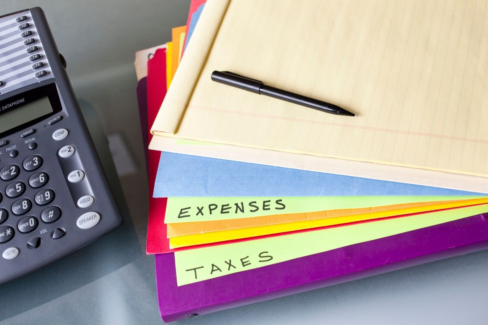 Calculator and business folders, labelled for taxes