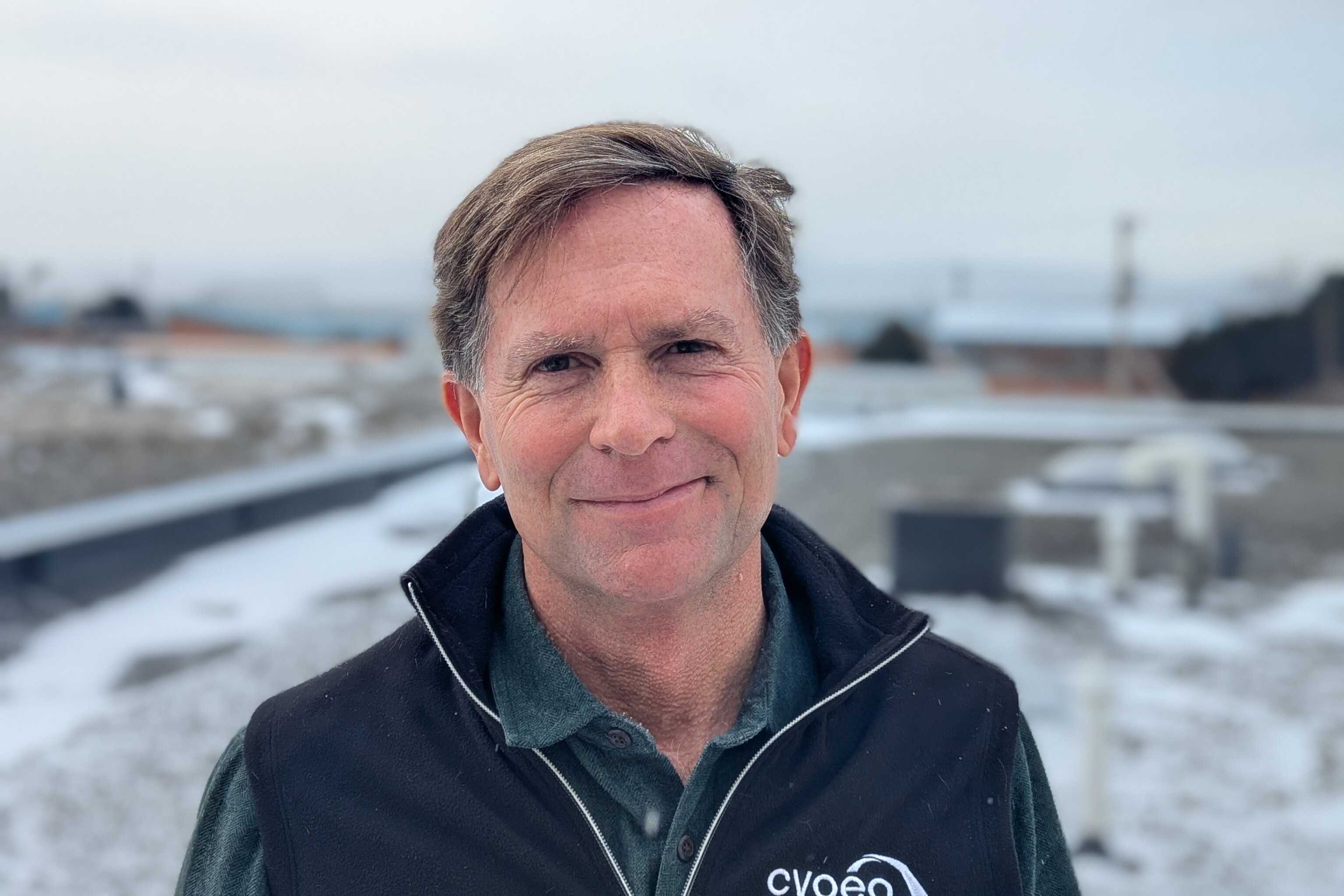 Headshot of Paul Dragon, smiling, outside.